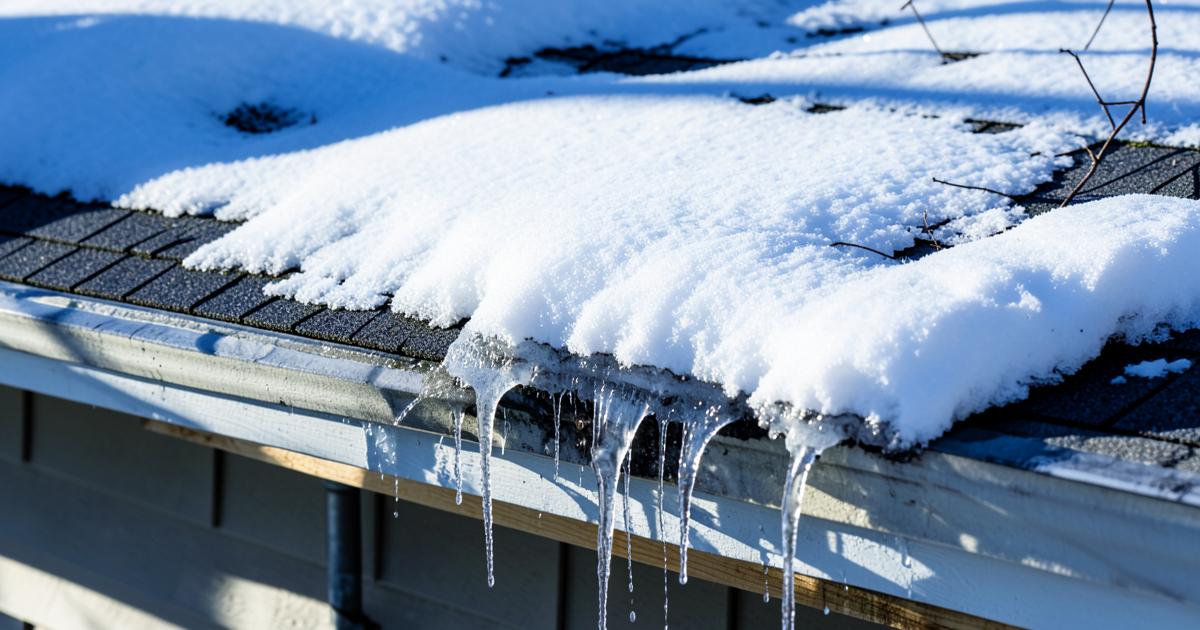 Snow-covered asphalt shingle roof during a Maine winter